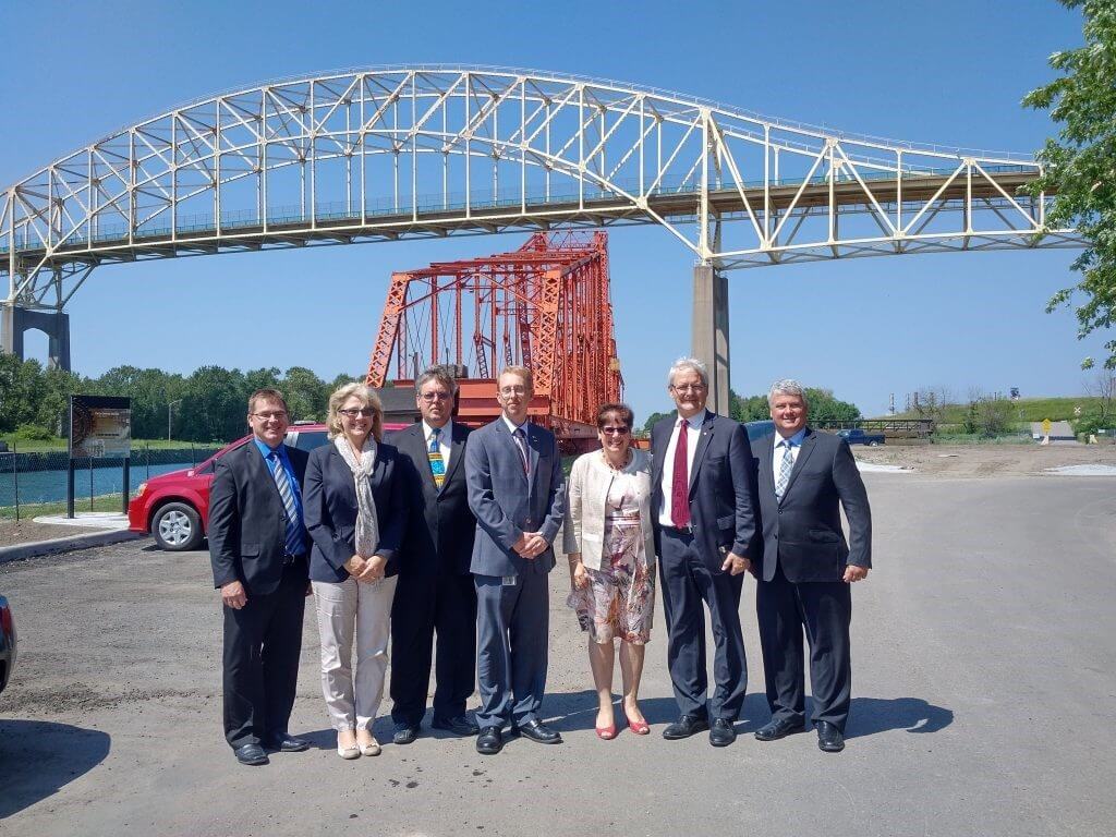 Surrounding The Honourable Marc Garneau MP, Minister of Transport (from right to left), are  Terry Sheehan, federal MP for Sault Ste. Marie,  Micheline Dubé, FBCL President and chief Executive Officer, Peter M. Petainen, International Bridge General Manager, Karl Hansen (MDOT), FBCL Board Vice-President Pascale Daigneault and Board director Rick Talvitie. 